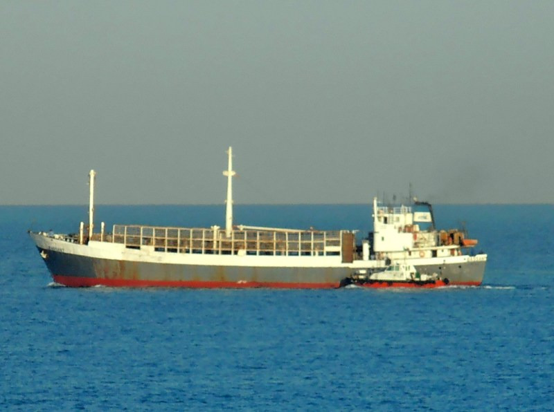 MV Bassant - Long white livestock carrier cruising on calm blue water with red hull base